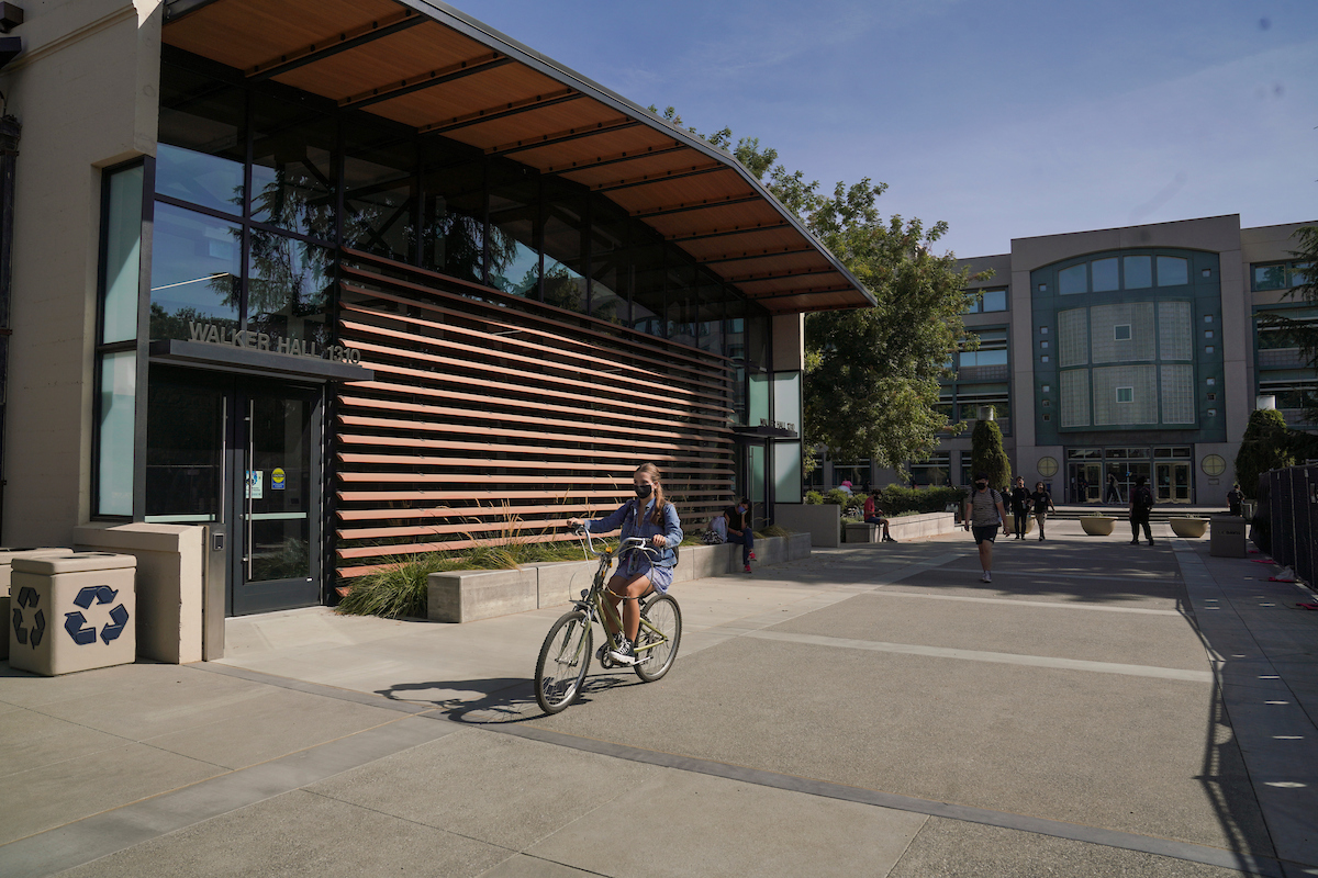 Image of UC Davis Walker Hall with a bicyclist riding by.