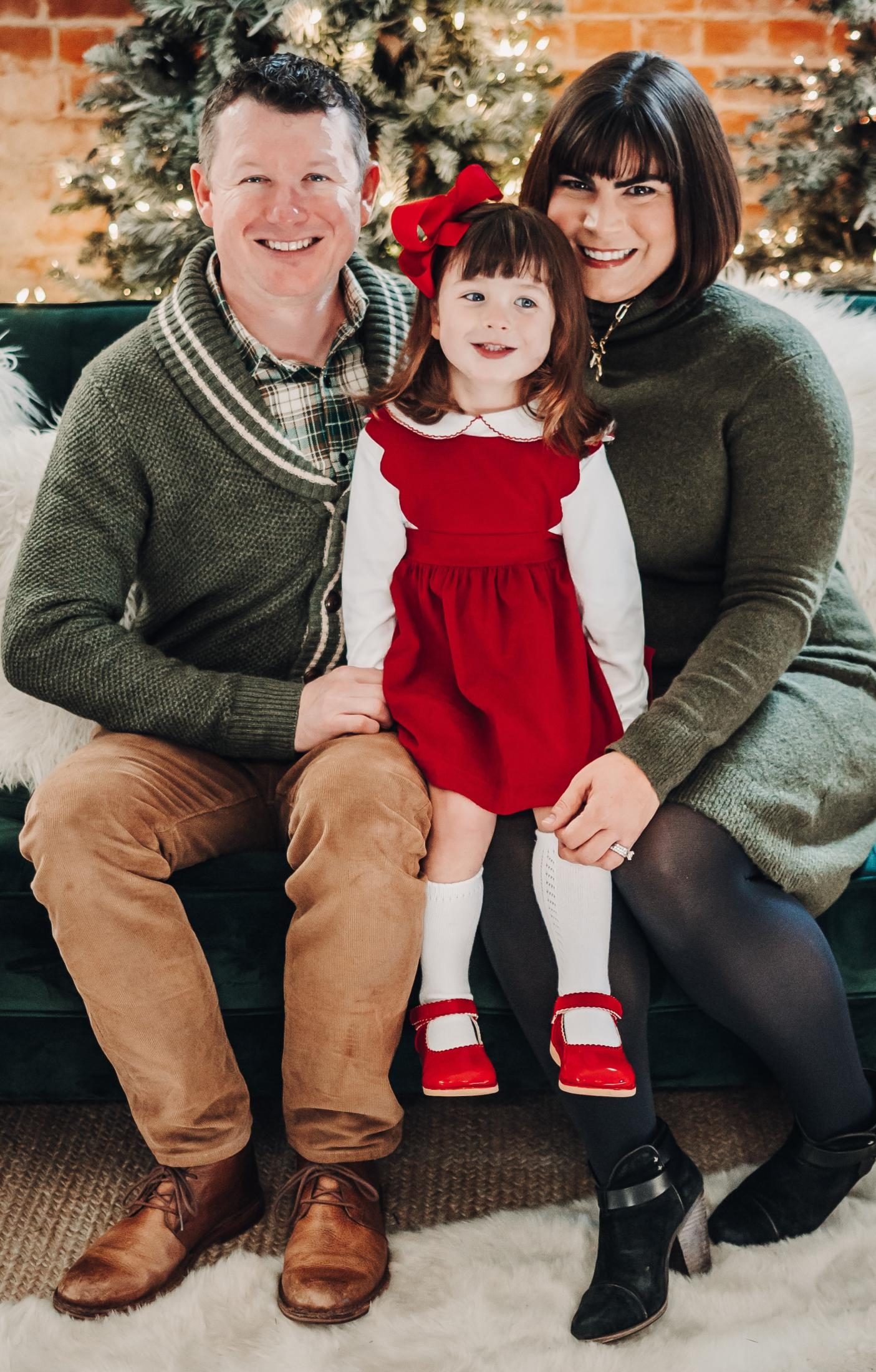 Leslie Carbahal poses for a photo with her husband and daughter