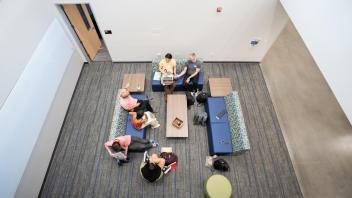 People sit in a circle on couches and chairs in the Chemistry Building addition