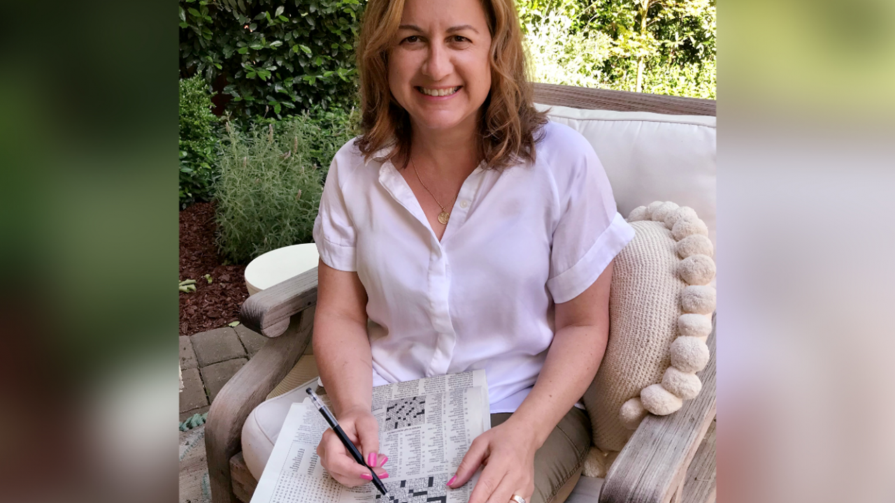 Image of Julie Nola doing a New York Times crossword puzzle.