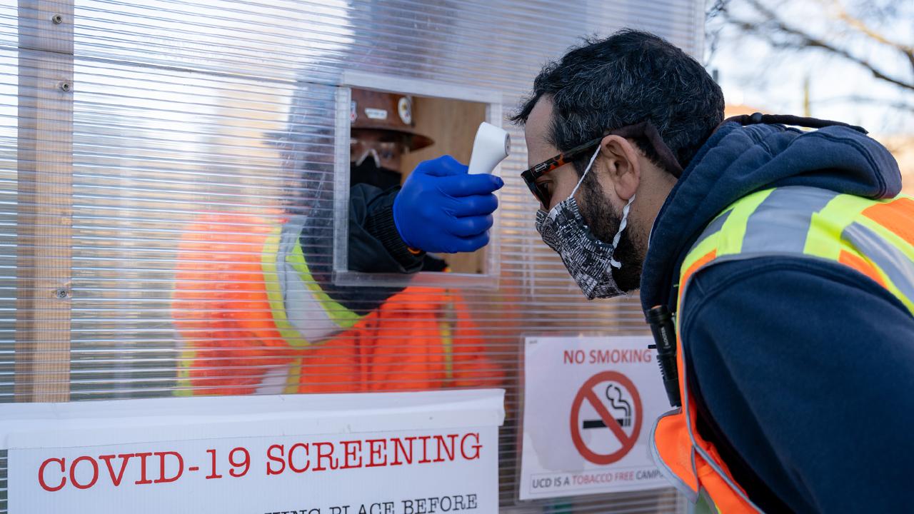Construction Worker at the Teaching and Learning Complex gets their temperature checked at the front gate. 