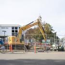 Fenced Big Shift construction site with an excavator outside Cruess Hall at UC Davis
