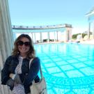 Lorin Torbitt poses, smiling in front of the Greek-style Neptune Pool at Hearst Castle