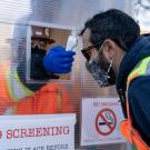 Construction Worker at the Teaching and Learning Complex gets their temperature checked at the front gate. 