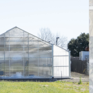 Photo of completed FPS greenhouse next to an aerial view of the area where the screenhouse will be located, adjacent to the greenhouse