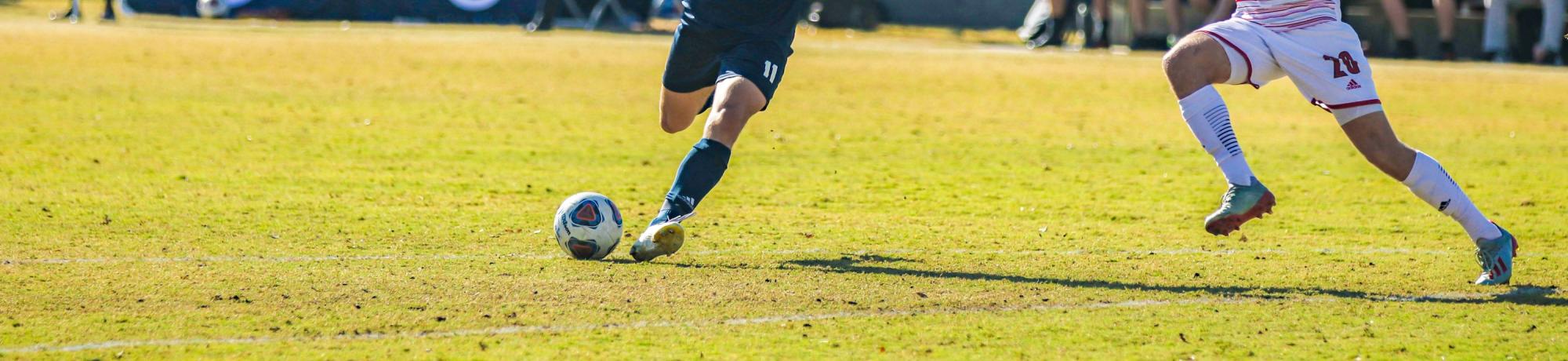 Two soccer players playing on a field at UC Davis